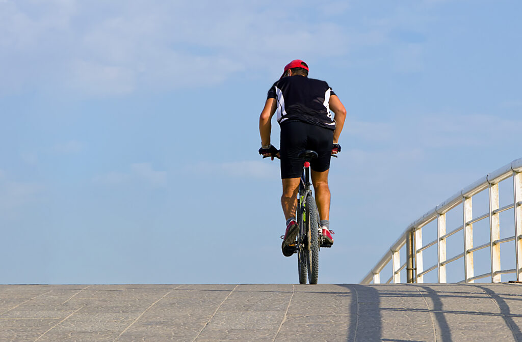 Bicyclist riding across a coastal bridge